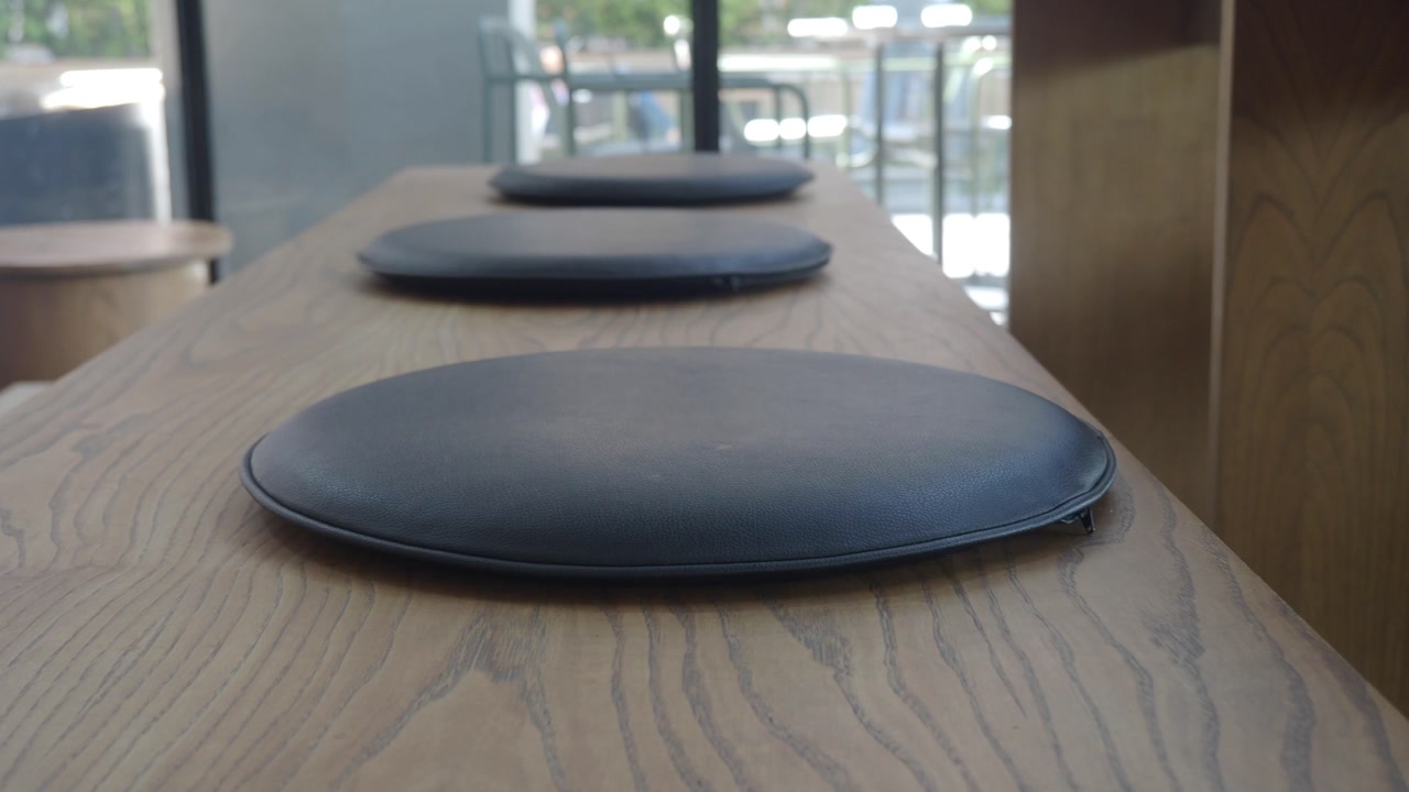 Modern Cafe Interior with Empty Wooden Bar Table and Cushions