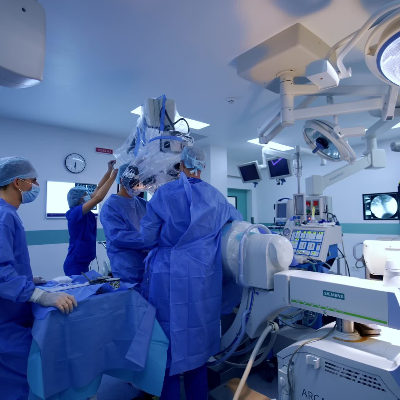 Well-equipped surgical room with advanced machines and devices. Surgeons stands near the high-precise microscope