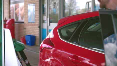 man refuelling a car at a petrol station