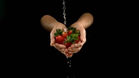 Water-pouring-on-hands-with-fresh-strawberries-4k