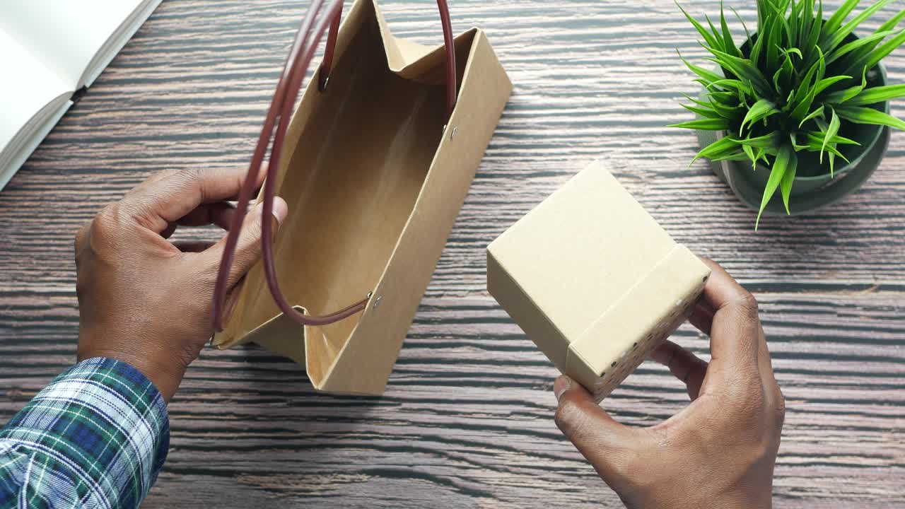 선물 상자 를 가진 선물 가방 을 열고 있는 사람