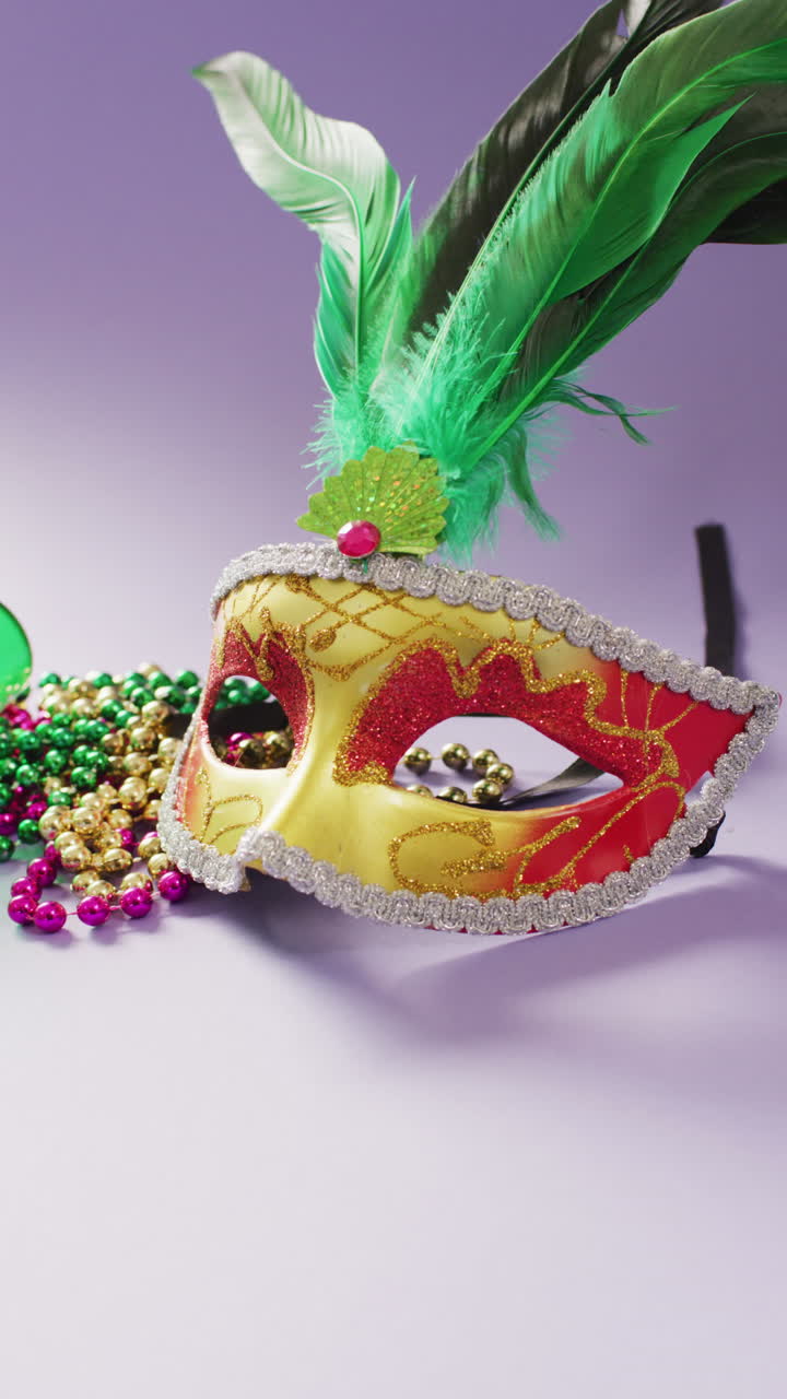 video vertical de máscara de mascarada con plumas y cuentas de carnaval de mardi gras en fondo lila