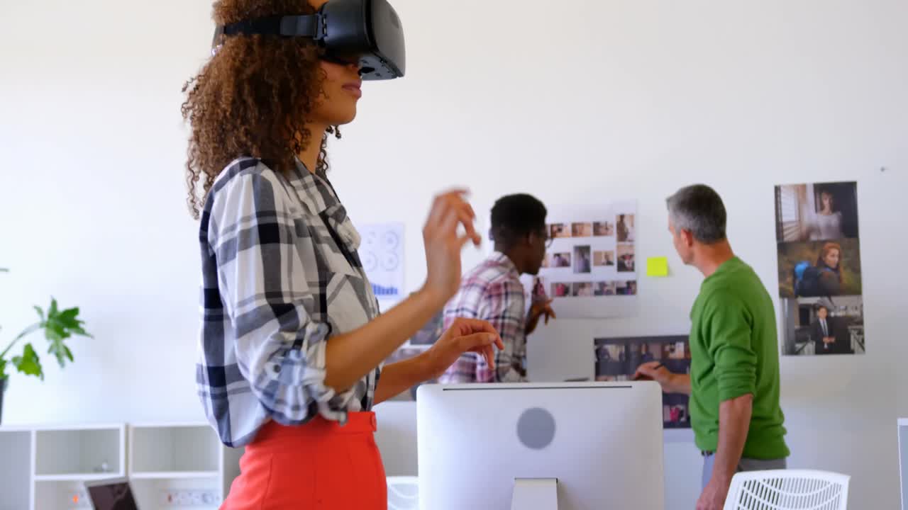 Pretty mixed-race female executives using virtual reality headset in modern office 4k