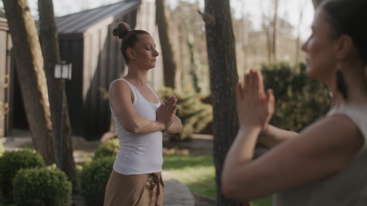 Women practicing yoga outdoors in a peaceful garden setting