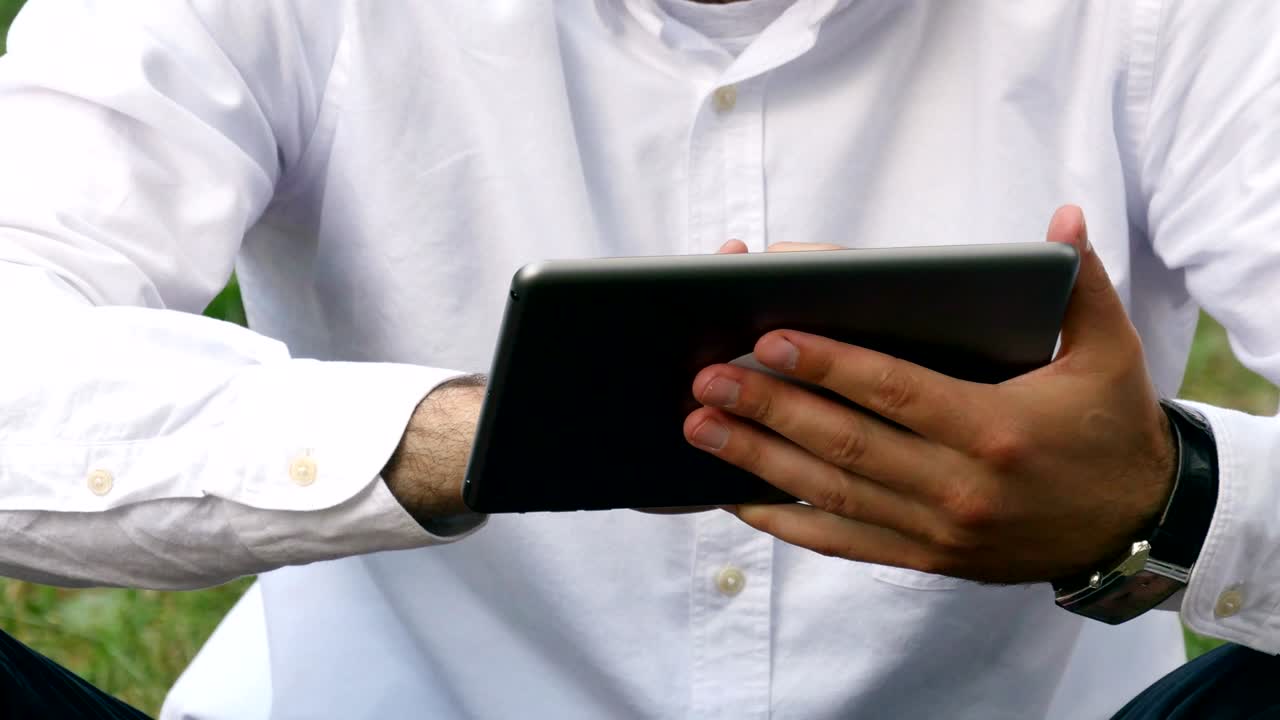 hombre de negocios mano usando dispositivo de tableta al aire libre