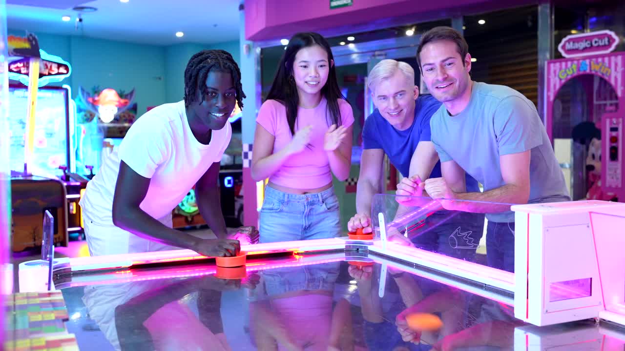 People playing air hockey in an arcade
