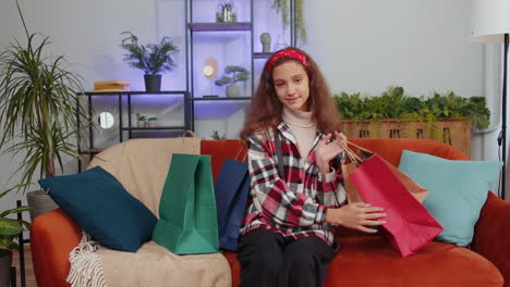 niña feliz niño niño adicto a las compras consumidor regresó a casa después de la venta de compras en línea con bolsas en casa