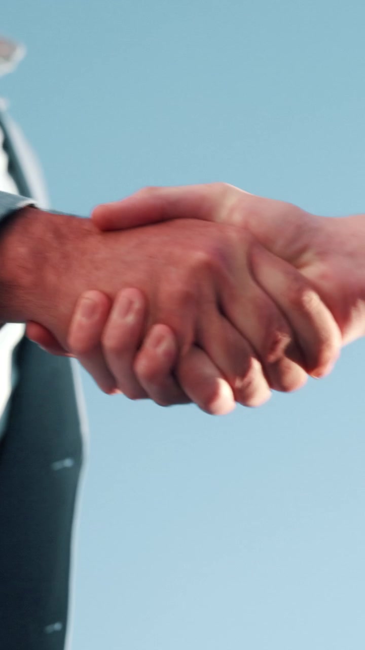 Due professionisti d'affari che si stringono la mano su sfondo blu