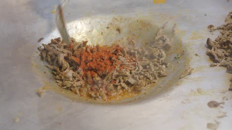 shredded meat cooking in a large pan