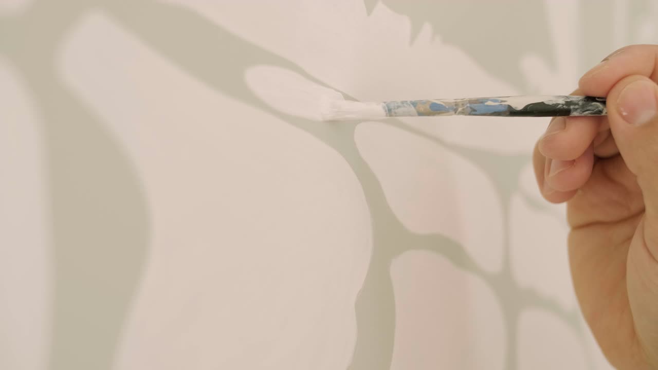 예술가는 어린이 방에서 그림으로 벽을 장식하고 있습니다. 새로운 집에서 벽의 예술 그림. 수리 작업.