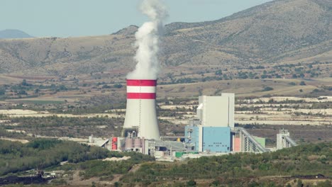 Coal-fired-power-station-plant-cooling-towers-emitting-Smoke-Steam-sunny-day-close-up