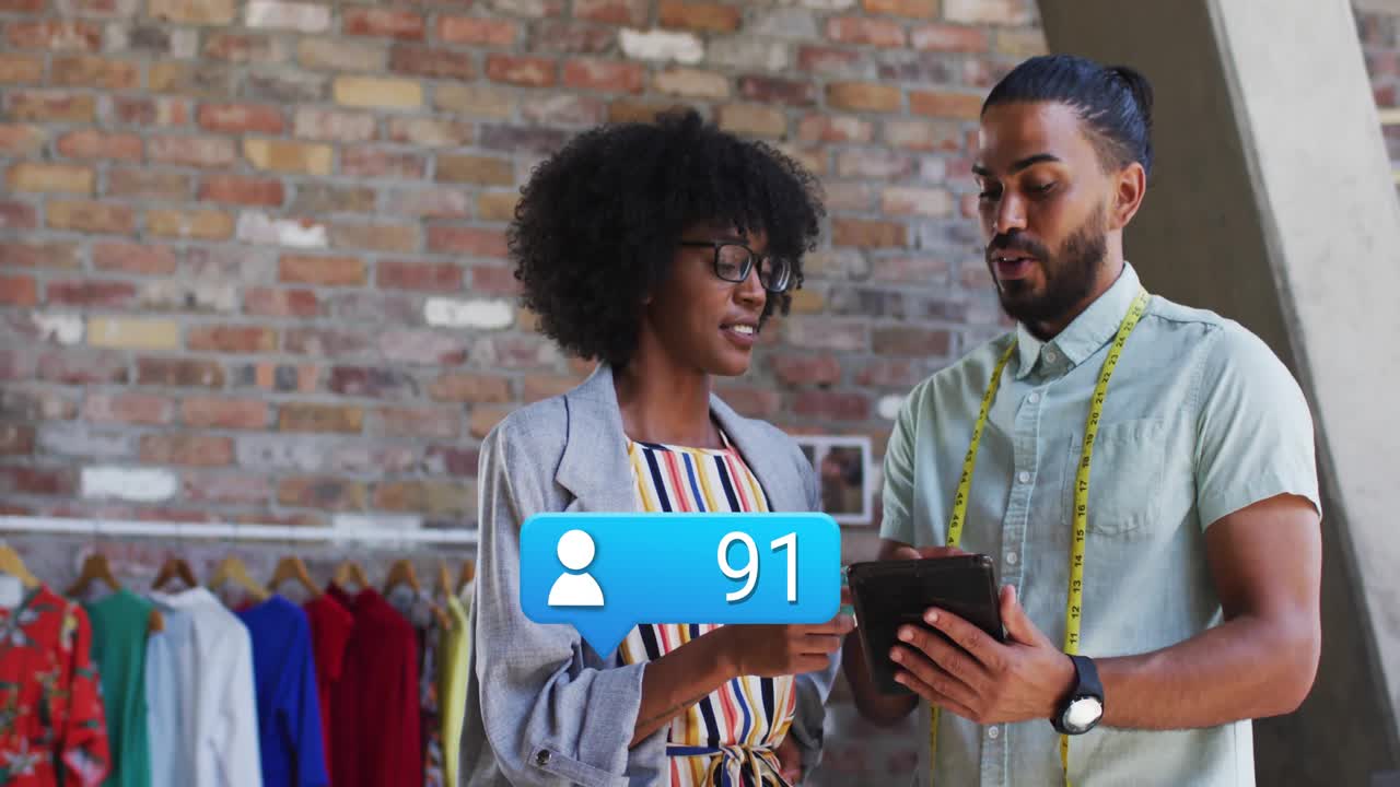 Fashion designers tapping and swiping tablet upon overlay appearance, monitoring user icons rising