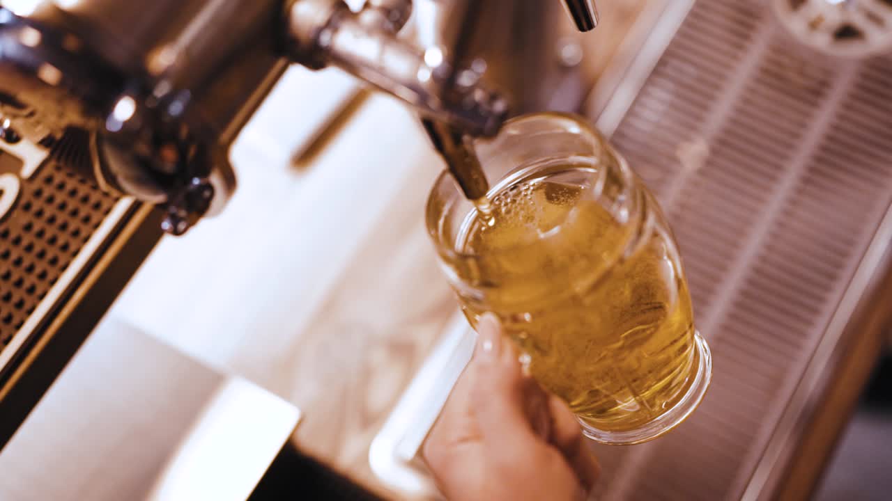camarero llenando un vaso de pinta con una cerveza artesanal rubia