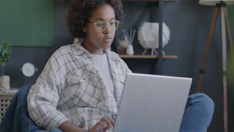 mujer trabajando en una computadora portátil en casa