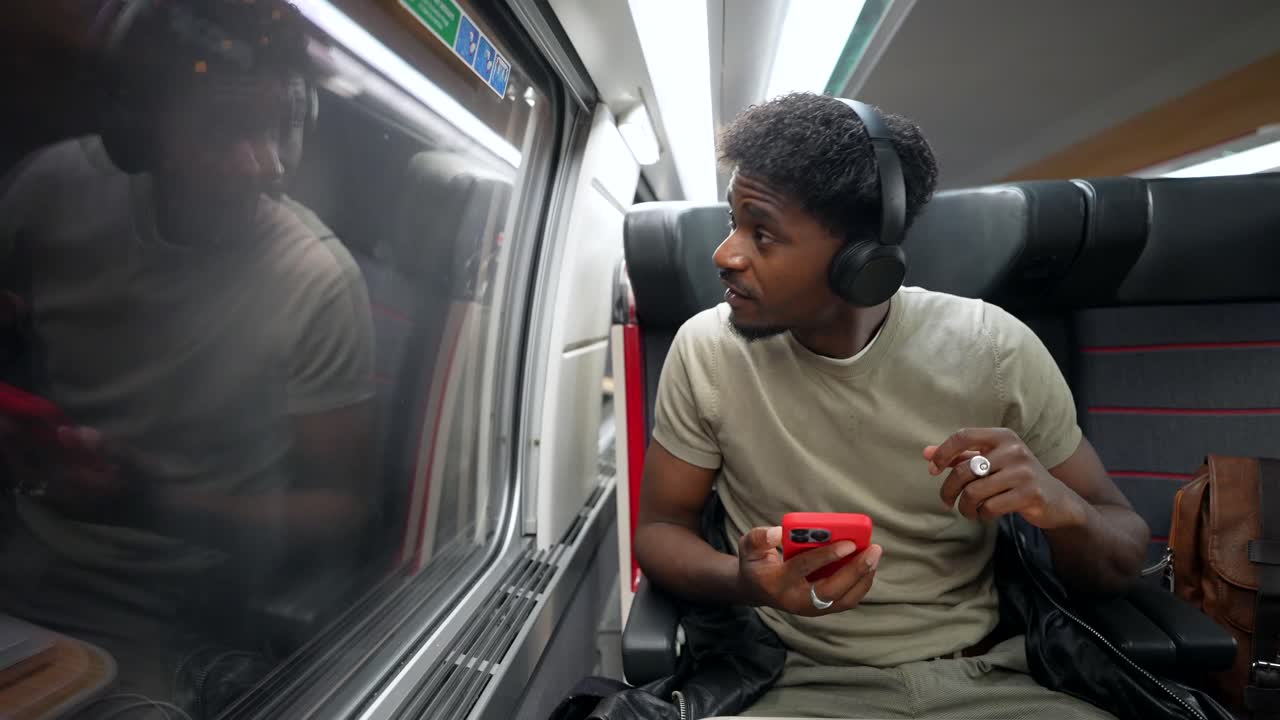 Man using mobile phone with headphones on a train
