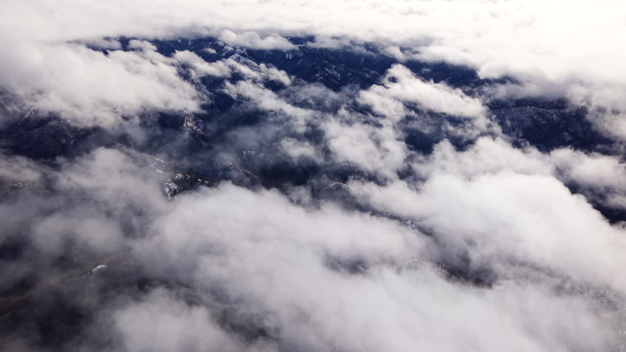 Kabarık bulutların altında yemyeşil dağların havadan görünümü, huzurlu atmosfer