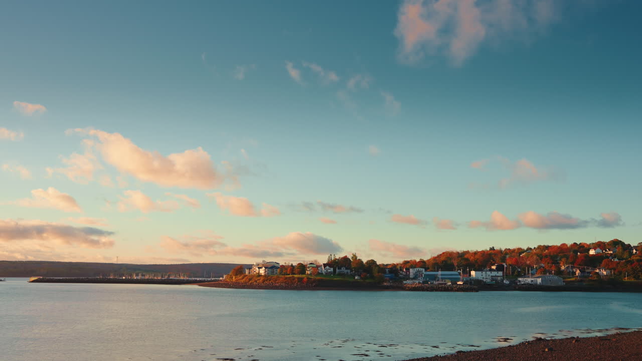 Picturesque Canadian landscape. Early morning first lights:view of the coastline, sea and fluffy colorful clouds. Tranquil and peaceful landmark.