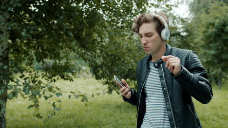 man dancing to music in a park
