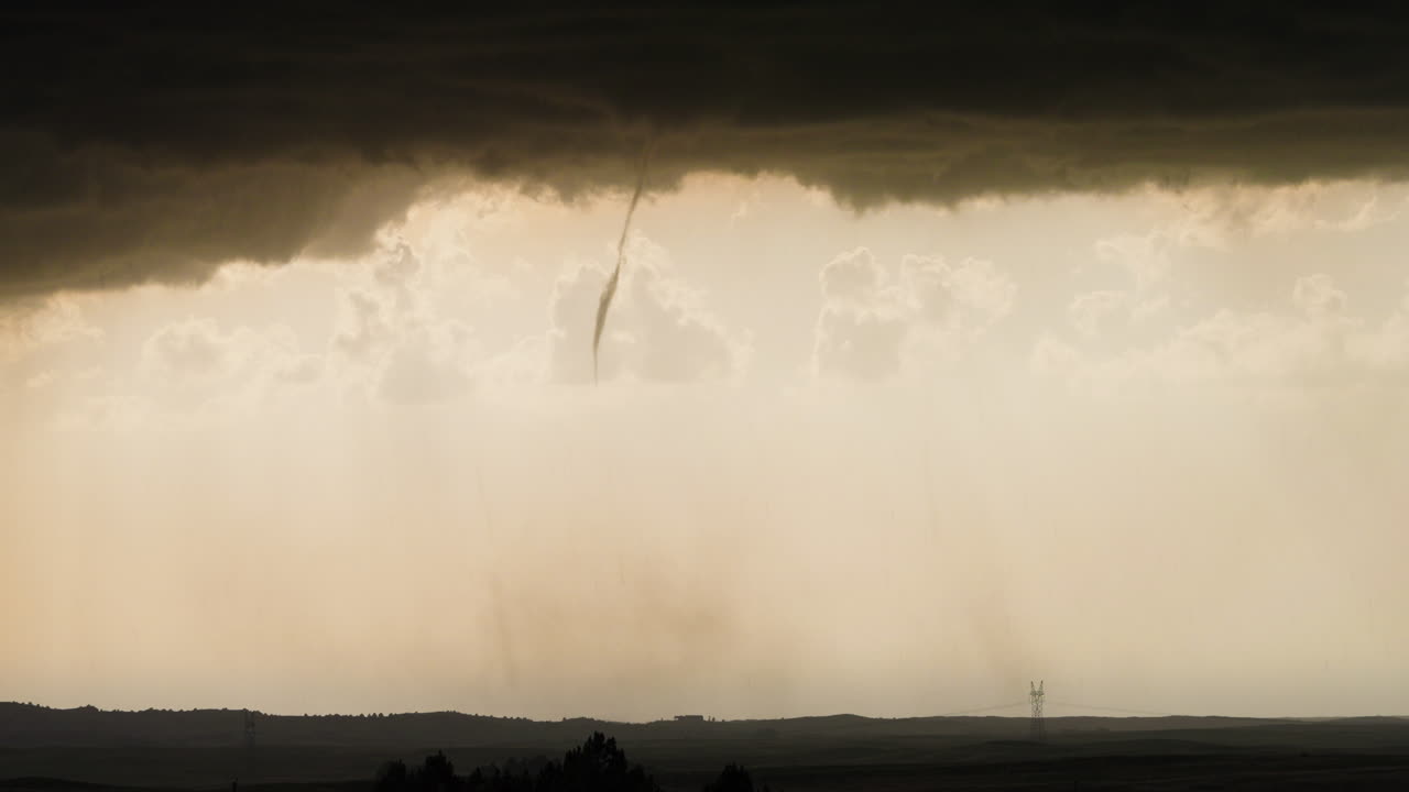 Dramatic Tornado Funnel Approaching Farmland with Dark Clouds