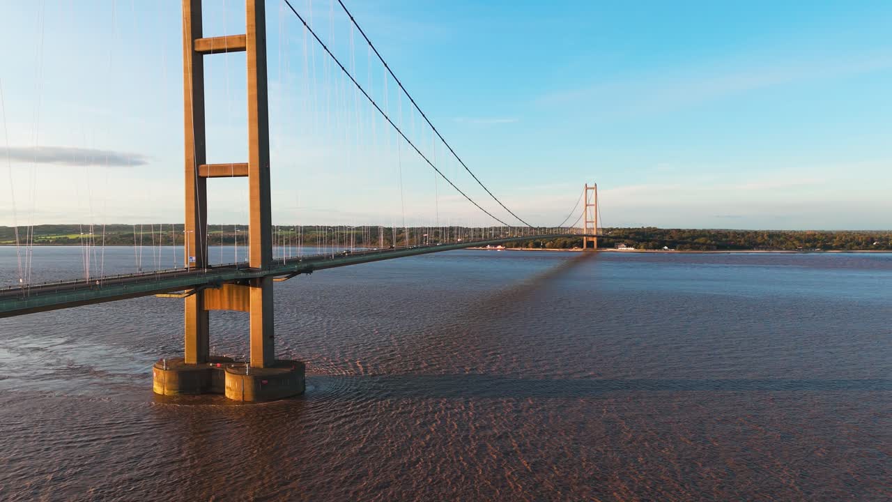 Sunset's charm: Aerial view of Humber Bridge with cars in motion