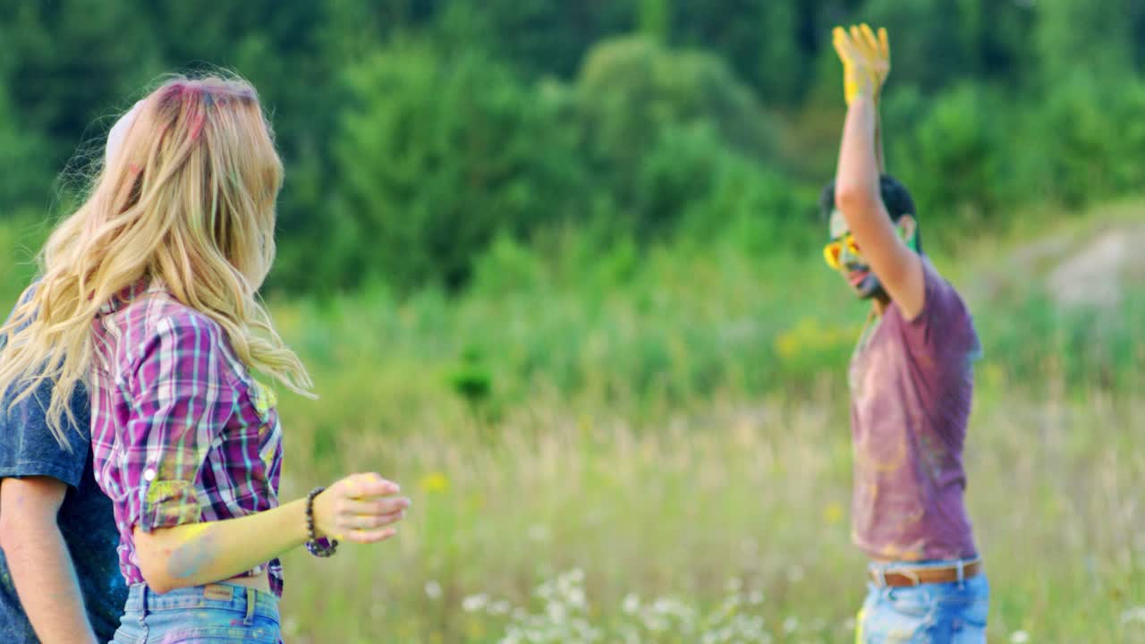 홀리 축제 기간 동안 들판에서 함께 어울리는 혼혈 젊은 행복한 친구들