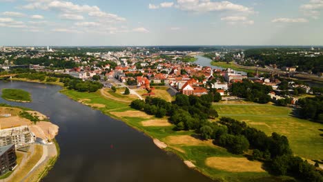 drone-shot-of-Kaunas-old-town-with-Kaunas-castle,-churches-and-other-old-red-roof-houses-between-two-rivers---Nemunas-and-Neris-in-Kaunas,-Lithuania-on-a-sunny-summer-day