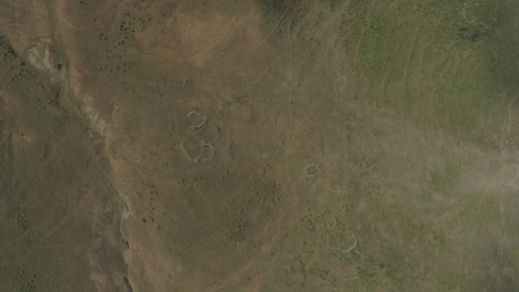 a drone flight flying over a mysterious and barely perceptible man-made structure with circular shapes