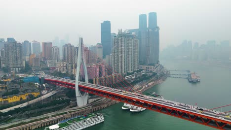 establishing drone shot of cityscape and the twin river bridges with train and cars above yangtze river during the day in chongqing, yuzhong district, china