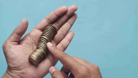 manos sosteniendo una pila de monedas