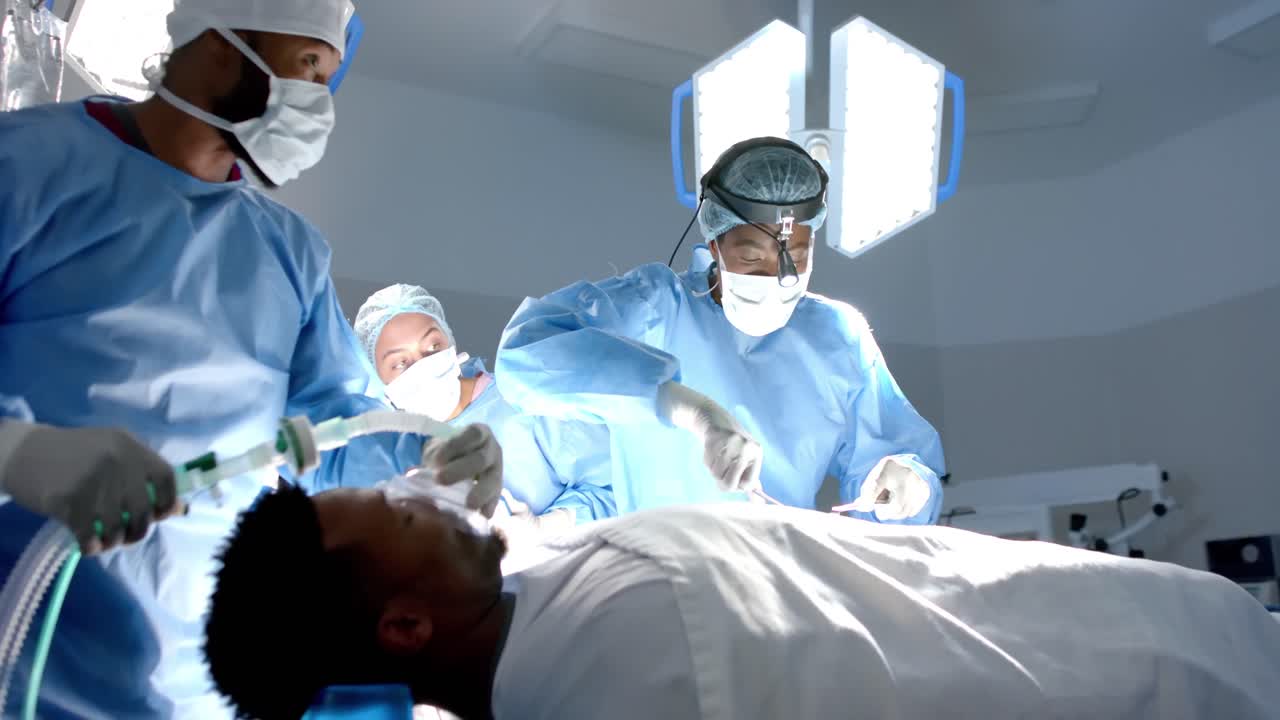 Diversi chirurghi e chirurghe in camice chirurgico, che operano un paziente, al rallentatore.