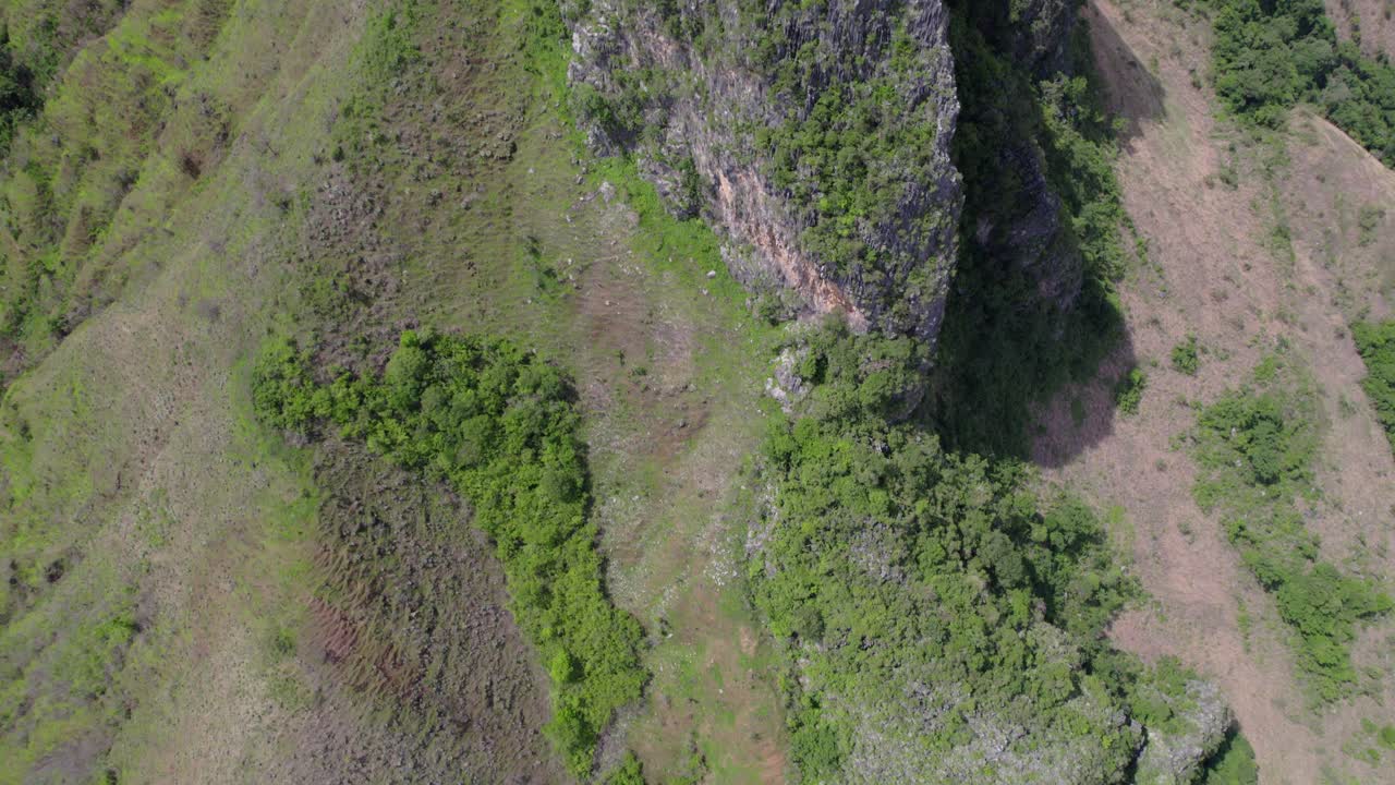 Aerial tilt up limestone rock formations with lush green vegetation, San Juan Venezuela