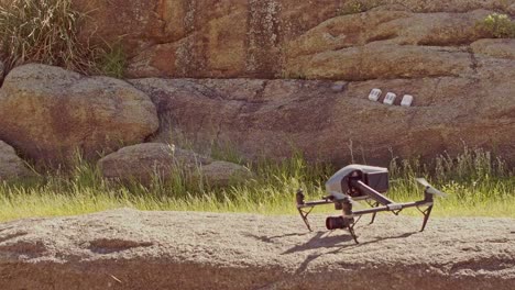 las palas de un dron cuadricóptero que giran lentamente se preparan para despegar y luego se van volando - plano medio