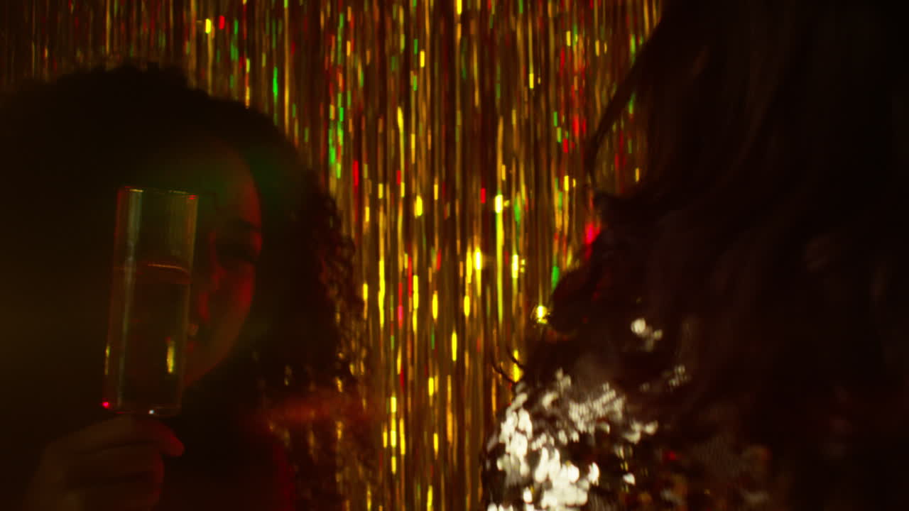 나이트클럽 바나 디스코에서 춤을 추는 두 여성이 반이는 불빛으로 알코올을 마시는 장면 12