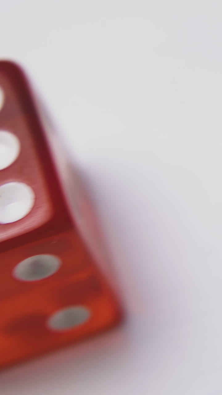 bright red plastic dices with different spots on sides lie on white background extreme close view