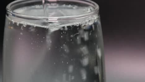 pouring mineral water into a glass. close-up shot