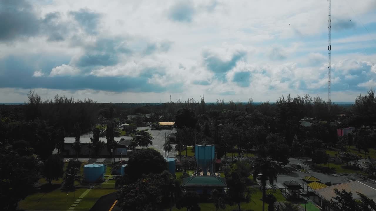 야자유 공장 폐수 거주지의 영화적 드론 영상은 인도네시아에 있는 야자나무 삼림 벌채로 둘러싸인 건물, 주택, 주요 도로 및 인프라로 구성되어 있습니다.