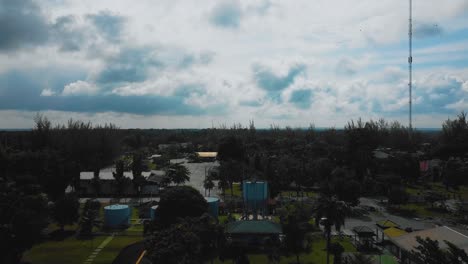 cinematic drone footage of palm oil mill effluent residential consists of buildings, homes, main road and infrastructure surrounded by palm oil trees deforestation located in indonesia in full hd