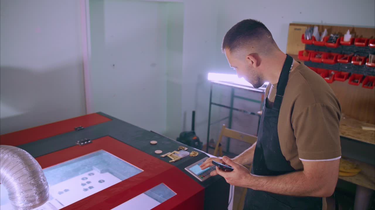 Man Operating Laser Cutting Machine in Workshop
