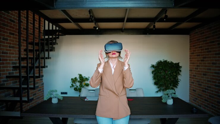 Donna che gesticola mentre usa un visore per la realtà virtuale in un ufficio