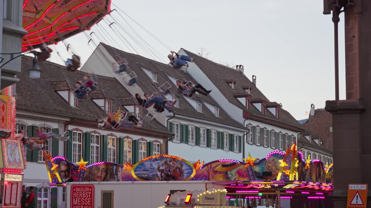People at the Basel Autumn Fair 2024 on the chain carousel on Münsterplatz