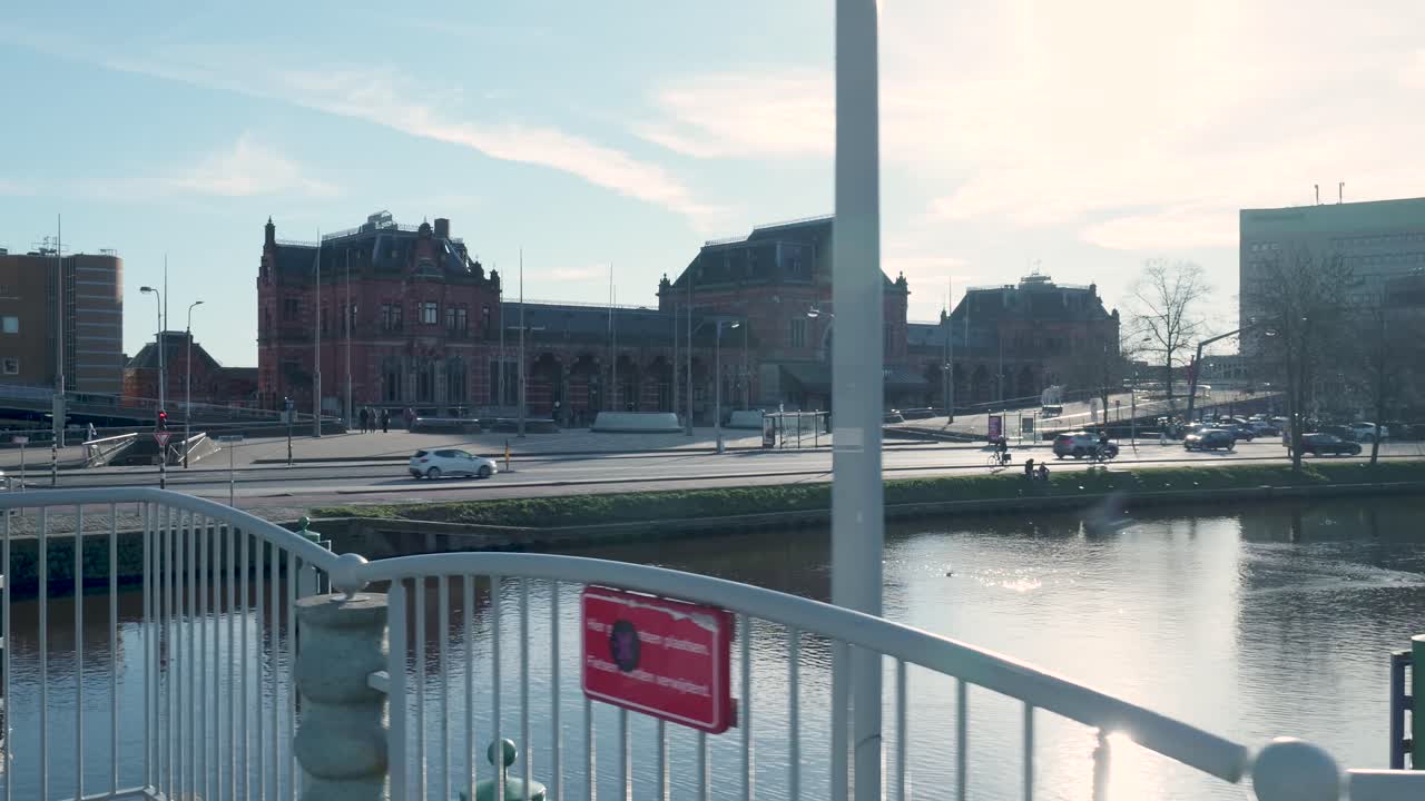 Groningen Hovedbanegård og kanal med bytrafik på en solrig dag