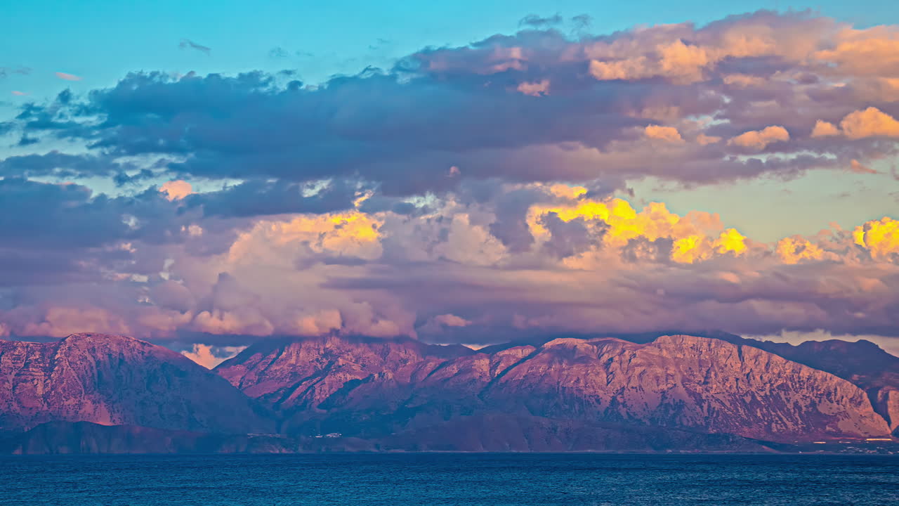 una hermosa puesta de sol sobre creta, grecia, con el mar mediterráneo y las nubes brillando en la luz dorada