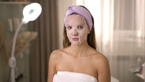 woman receiving a skincare treatment with a facial mask
