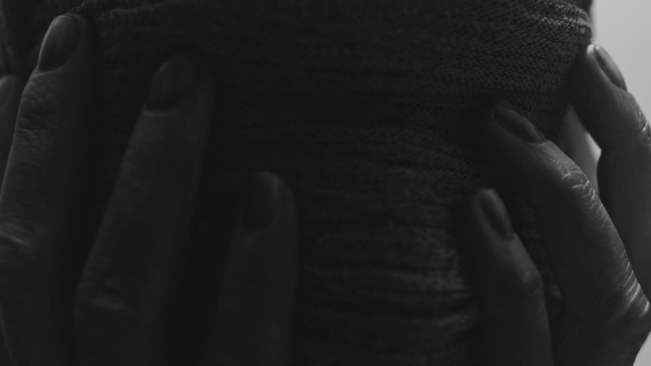 A mummified woman against the bright background in keeps her hands on her face the powerful pose full of despair