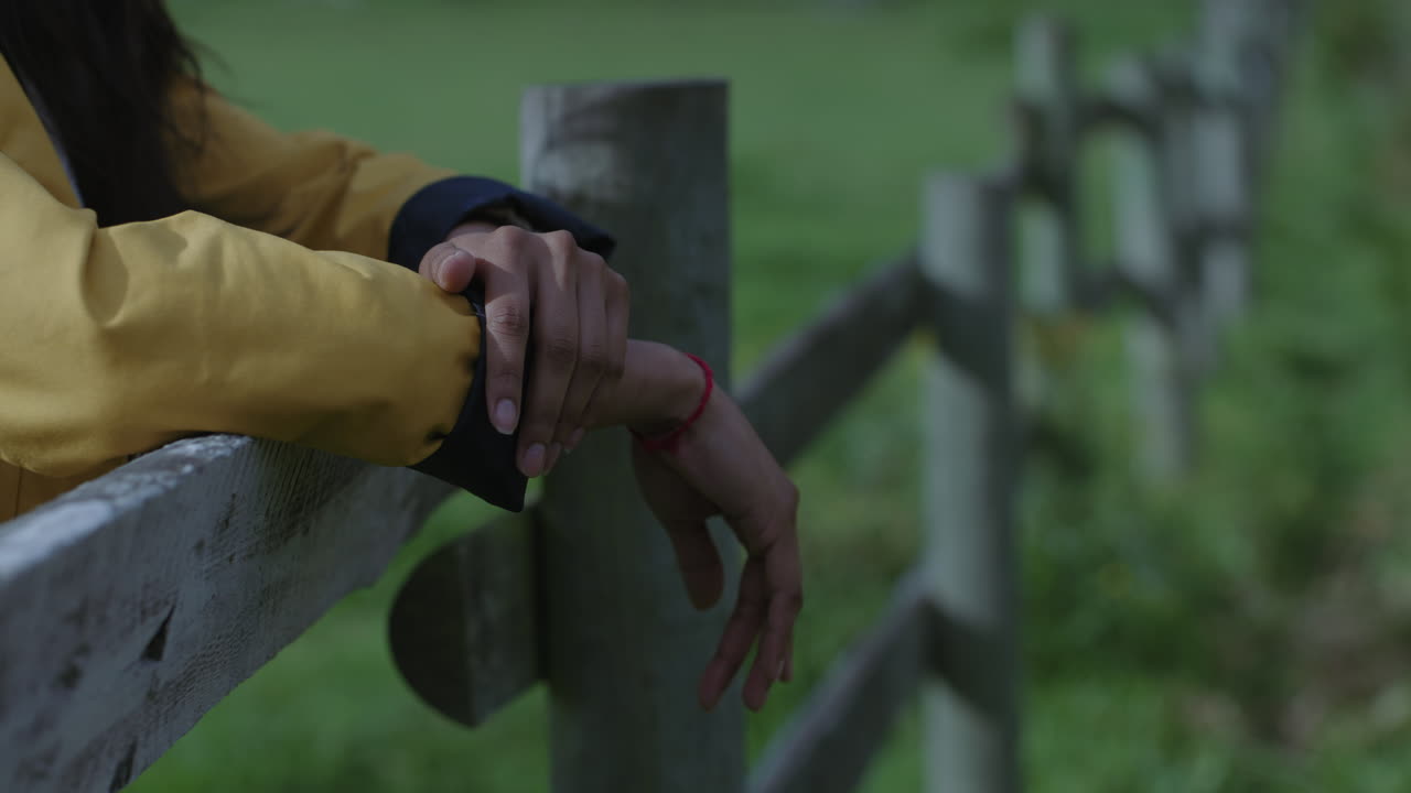 mujer joven manos excursionista turista descansando en la valla de madera relajándose en el campo verde granja concepto de estilo de vida tranquilo