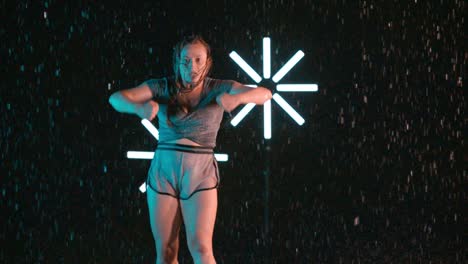 young caucasian female dancer performing modern hip hop dancing, indoor rain effect
