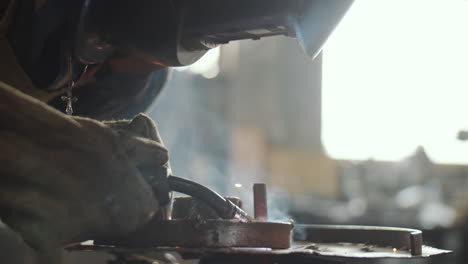 Blacksmith-in-Helmet-Welding-Iron-at-Work