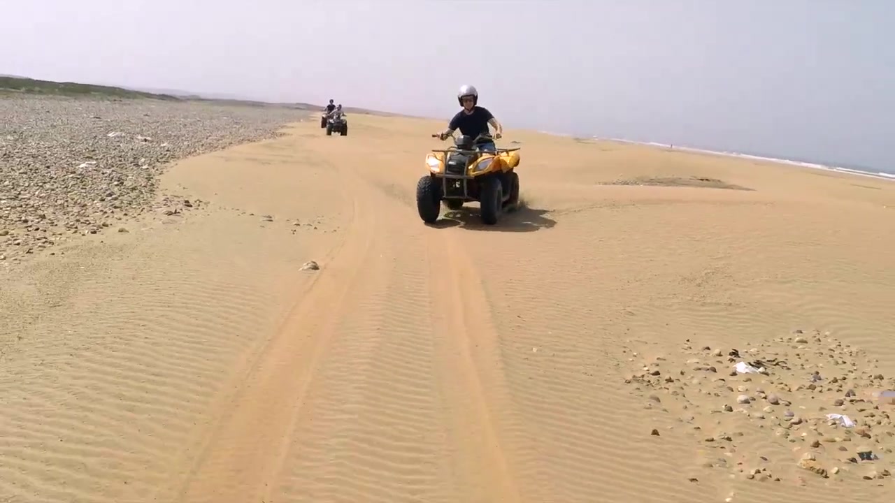 Inquadratura cinque. Ripresa d'azione in tracking di quad su una spiaggia deserta in Marocco.