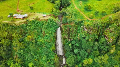 Aerial view of a waterfall and a plateau and moving backwards revealing the horizon