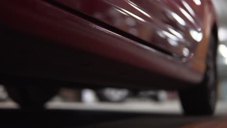 man getting into car on drivers side. closeup view from below, legs in boots.
